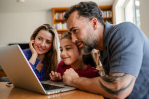 Parents And Daughter Booking Holiday Accommodation Online.